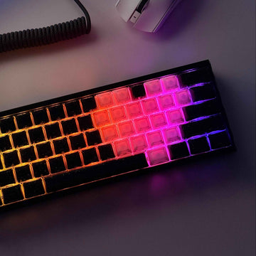 Gaming keyboard with RGB lighting on a desk next to a mouse and monitor. Black jelly keycap with glitter