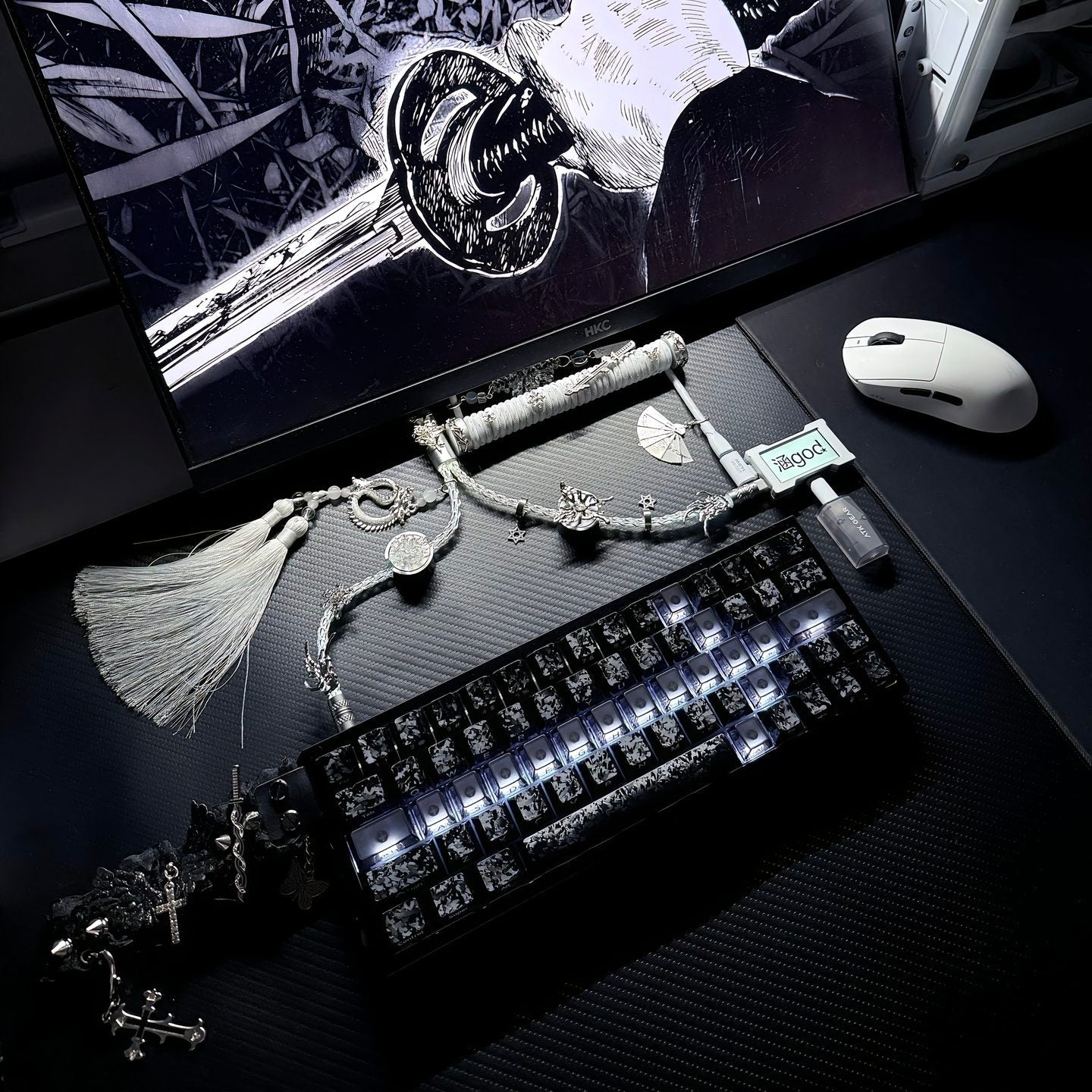 Dark-themed desk setup with a computer monitor, keyboard, mouse, and decorative items.